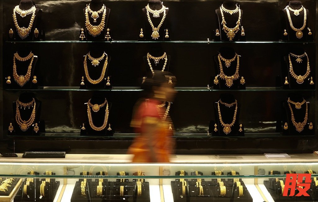 4月20日，印度班加罗尔，一名女性走过一家珠宝店的金饰展柜。（视觉中国）
